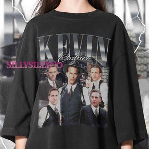 Könnte beinhalten: Schwarzes T-Shirt mit einem Vintage-Design von Kevin Costner. Die Grafik zeigt mehrere Bilder des Schauspielers in Anzug und Hut. Der Name "Kevin Costner" ist in silberner, strukturierter Schrift über den Bildern gedruckt.
