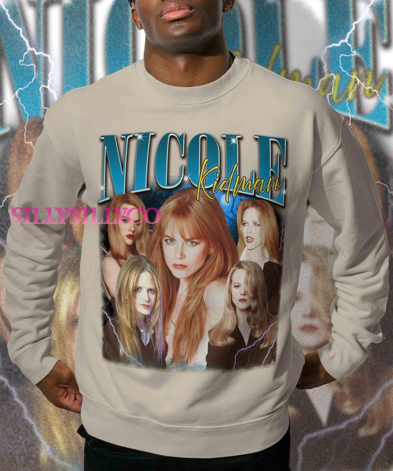 Puede incluir: Sudadera beige con un collage de im&aacute;genes de Nicole Kidman y el nombre "Nicole Kidman" en texto azul y amarillo. El dise&ntilde;o incluye gr&aacute;ficos de rayos y una est&eacute;tica vintage.