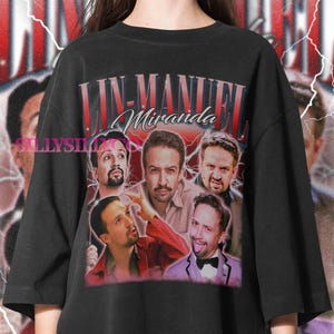 May include: Black t-shirt featuring a graphic of Lin-Manuel Miranda with the text "Lin-Manuel Miranda" in red and white. The graphic includes multiple images of the actor. The shirt has a vintage style.