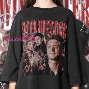 May include: Black t-shirt featuring a vintage-style graphic with the word "Winchester" in red, and three men's faces. The shirt has a distressed look, with the text "Dean" below "Winchester". The brand name "SillySilkCo" is printed on the left side.