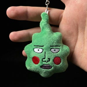 Könnte beinhalten: Ein Set aus drei Keramikbechern mit gesprenkelter, matter Oberfläche. Die Becher sind in Creme-, Hellgrau- und Dunkelgrautönen gehalten. Jede Tasse hat ein schlichtes, minimalistisches Design.