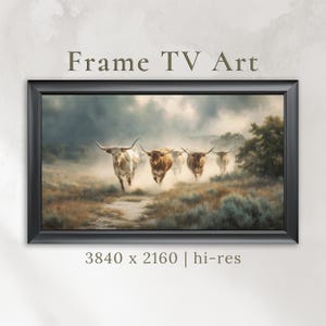 May include: A framed digital art print featuring a herd of longhorn cattle running through a dusty field. The artwork is in a rectangular black frame and includes the text "Frame TV Art" at the top. The image resolution is 3840 x 2160.