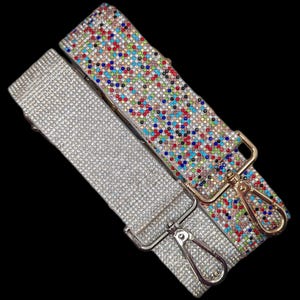 May include: Two decorative purse straps. One is silver with a dense pattern of small, reflective rhinestones. The other strap has a white base and is covered in a colorful mosaic of rhinestones in various colors. Both straps have metal clasps.