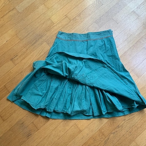 Pu&ograve; includere: Gonna color turchese con un design a balze a strati. La gonna ha un girovita aderente con cuciture arancioni. La gonna &egrave; realizzata in un tessuto leggero ed &egrave; adatta per un abbigliamento casual. Misura circa 76 cm di lunghezza.