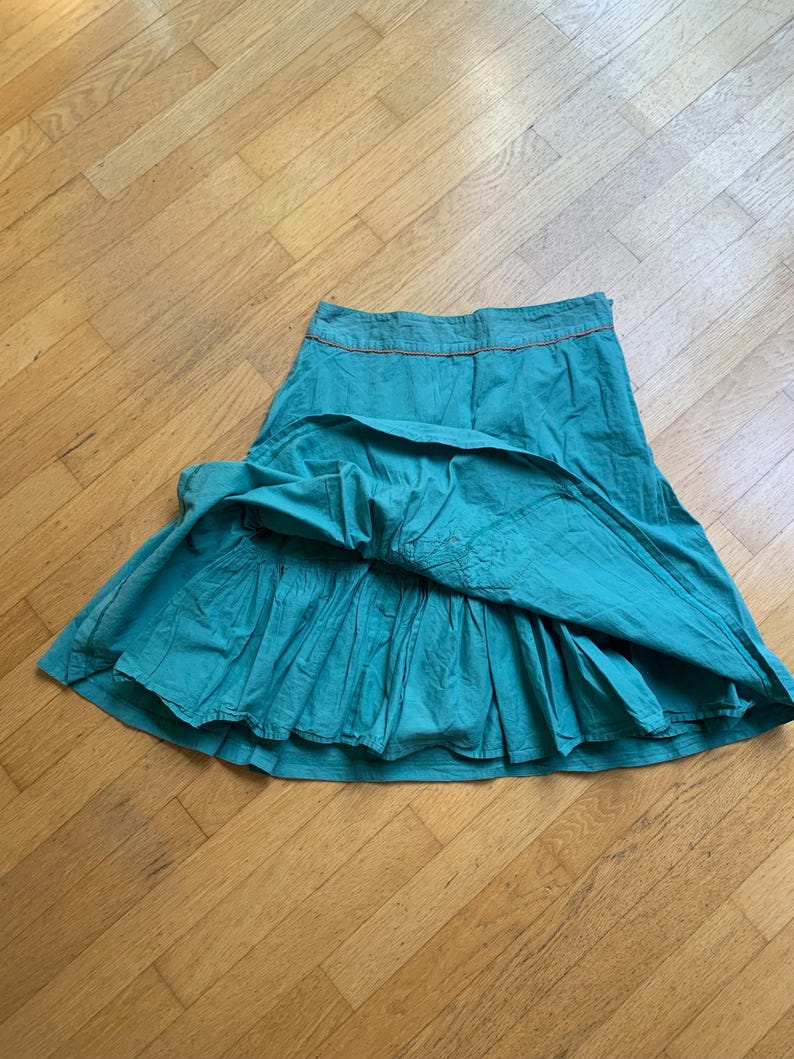 Pu&ograve; includere: Gonna color turchese con un design a balze a strati. La gonna ha un girovita aderente con cuciture arancioni. La gonna &egrave; realizzata in un tessuto leggero ed &egrave; adatta per un abbigliamento casual. Misura circa 76 cm di lunghezza.