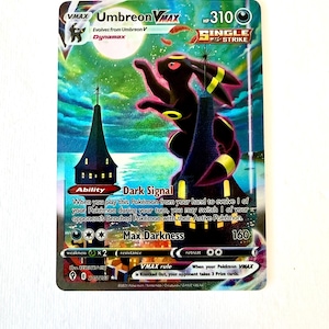 May include: A Umbreon VMAX trading card featuring a large black Pokémon with yellow rings perched on a dark tower under a full moon. The card displays 310 HP, the Single Strike logo, and text including Dark Signal and Max Darkness abilities.