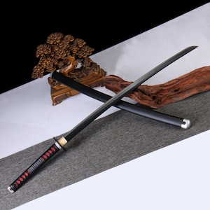 May include: A black katana sword with a black scabbard. The handle is wrapped in black material with red diamond-shaped accents. The blade is straight and has a silver-colored metal guard.