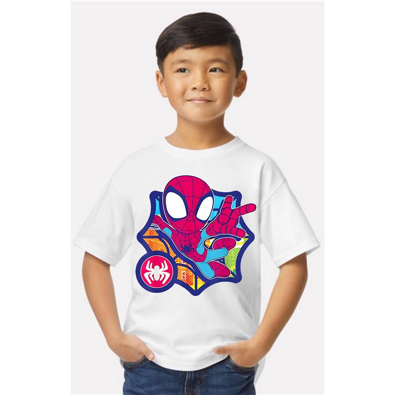 K&ouml;nnte beinhalten: Wei&szlig;es T-Shirt mit einem farbenfrohen Spider-Man-Motiv. Das Design zeigt eine rot-blaue Spider-Man-Figur in einer Web-Schleuder-Pose, vor einem mehrfarbigen Hintergrund. Ein Spider-Man-Logo ist ebenfalls vorhanden.