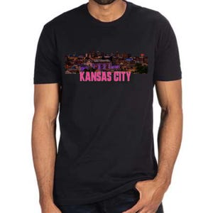 May include: Black t-shirt with a skyline of Kansas City in purple and pink with the text "KANSAS CITY" in pink.