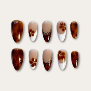 Peut inclure: Une tasse en céramique blanche avec une anse noire et le texte "But First, Coffee" dans un style manuscrit. La tasse est posée sur une surface blanche. La tasse mesure environ 10 cm de haut.