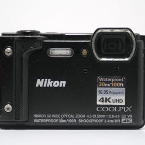 May include: A black Nikon Coolpix camera with a 5x wide optical zoom lens. The camera is waterproof to 30 metres and shockproof to 2.4 metres. It features 16.05 megapixels and 4K UHD video recording.