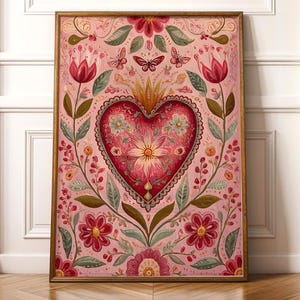 May include: A framed print featuring a large, ornate heart at the center, surrounded by floral and butterfly motifs. The heart is a deep red with intricate details, set against a soft pink background. The artwork is in a wooden frame.