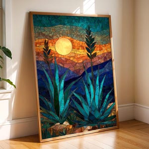 Puede incluir: Obra de arte en mosaico enmarcada que representa un paisaje desértico con plantas de agave y un sol poniente. La pieza utiliza tonos azules, naranjas y dorados, enmarcada en madera. La técnica del mosaico proporciona un acabado texturizado.