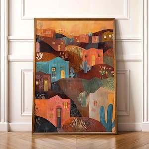 Könnte beinhalten: Ein gerahmter Kunstdruck, der eine farbenfrohe Wüstenlandschaft zeigt. Das Kunstwerk zeigt stilisierte Häuser in Orange-, Türkis- und Brauntönen, mit Kakteen und anderen Wüstenpflanzen. Die warme Farbpalette und die einfachen Formen schaffen eine charmante Szene.