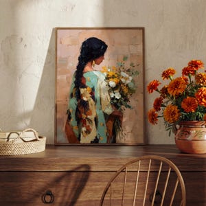May include: A framed painting depicts a person with dark hair holding a bouquet of flowers. The person wears a teal and patterned garment. The background is a textured, neutral color. A vase of orange flowers sits on a wooden surface.