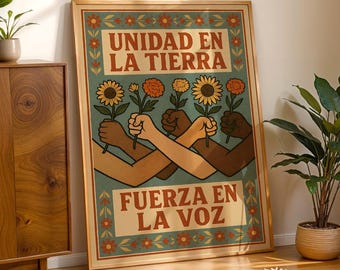 May include: A framed poster with the text "UNIDAD EN LA TIERRA" and "FUERZA EN LA VOZ". The poster features illustrations of hands holding flowers in front of a teal background. The frame is a light brown color.