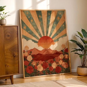 May include: A framed art print featuring a retro sunset design with a red sun, radiating light, and mountains. The artwork includes a field of roses in shades of red and cream. The print is displayed in a room with wooden furniture and plants.