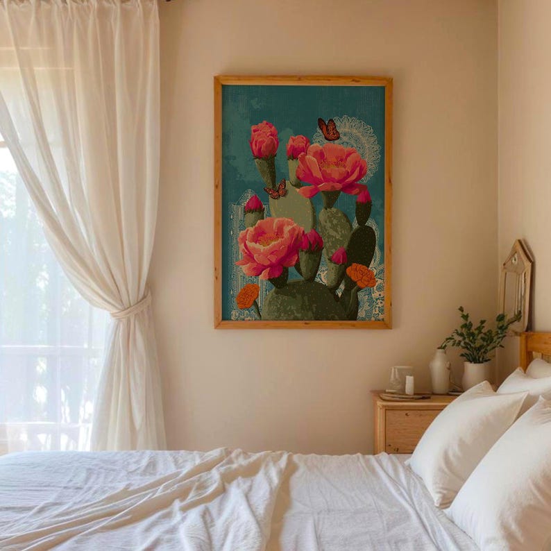 May include: A framed art print featuring a cactus with large pink flowers and butterflies against a teal background. The artwork is in a wooden frame and hangs on a light-colored wall, adding a touch of nature-inspired decor to the room.