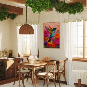 May include: A dining room scene with a wooden table and chairs, a framed hummingbird painting, and a woven pendant light. The painting shows a colourful hummingbird amongst bright flowers. White curtains frame the windows.