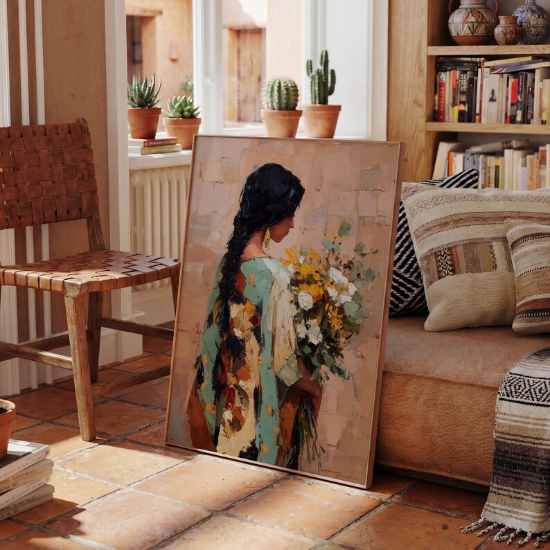 May include: An oil painting depicts a woman with long black hair holding a bouquet of white and yellow flowers. She wears a turquoise and patterned shawl. The artwork is in a wooden frame and leans against a wall in a room with terracotta tile flooring.