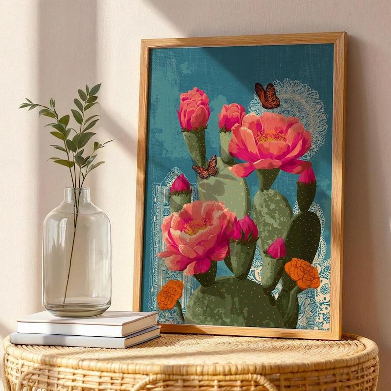 May include: A framed art print featuring a vibrant illustration of a cactus with large pink flowers and orange accents against a teal background. Butterflies and decorative patterns add detail to the botanical artwork.