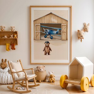 Set of 3 digital nursery prints featuring an aviator bear, vintage biplanes, and cozy airplane hangar scenes. Perfect for an aviator nursery, airplane nursery, baby boy travel room, pilot baby room, vintage nursery decor, and adventure-themed baby rooms. Ideal wall art for baby showers, nursery wall displays, and cozy baby room corners. Soft neutral colors with a classic vintage aviation theme.