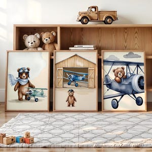 Set of 3 digital nursery prints featuring an aviator bear, vintage biplanes, and cozy airplane hangar scenes. Perfect for an aviator nursery, airplane nursery, baby boy travel room, pilot baby room, vintage nursery decor, and adventure-themed baby rooms. Ideal wall art for baby showers, nursery wall displays, and cozy baby room corners. Soft neutral colors with a classic vintage aviation theme.
