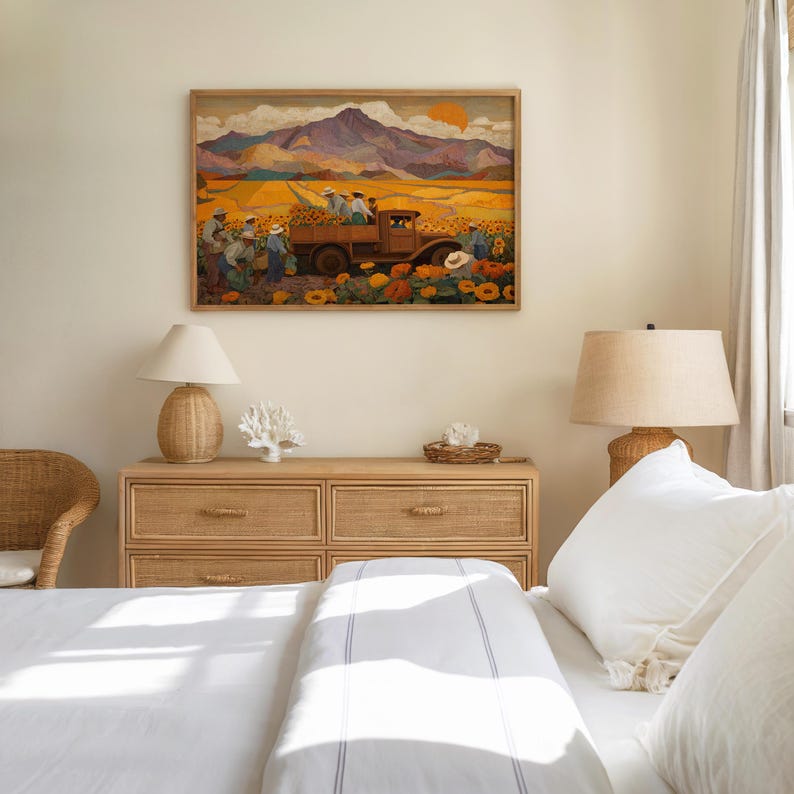 May include: A framed artwork depicts a harvest scene with a truck, sunflowers, and figures in a field. The artwork is mounted above a wooden dresser with a lamp, coral, and decorative basket. The room has a neutral color palette.
