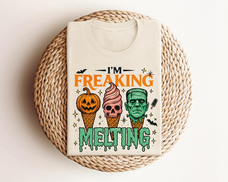 K&ouml;nnte beinhalten: Cremefarbenes T-Shirt mit einem Halloween-Motiv. Das Design zeigt drei Eiswaffeln mit gruseligen Gesichtern: einen K&uuml;rbis, einen Totenkopf und Frankensteins Monster. Der Text "I'M FREAKING MELTING" befindet sich &uuml;ber und unter den Kegeln.