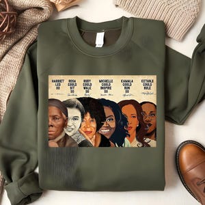 May include: Green sweatshirt with a graphic print of six women, including Harriet Tubman, Rosa Parks, Ruby Bridges, Michelle Obama, Kamala Harris, and Ketanji Brown Jackson. The text reads "Harriet Led 80, Rosa Could Sit 50, Ruby Could Walk 50, Michelle Could Inspire 50, Kamala Could Run 50, Ketanji Could Rule".