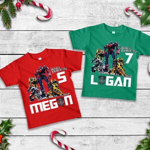 May include: Two red and green t-shirts with a Transformers graphic and the names Megan and Logan. The shirts have the numbers 5 and 7 on them.