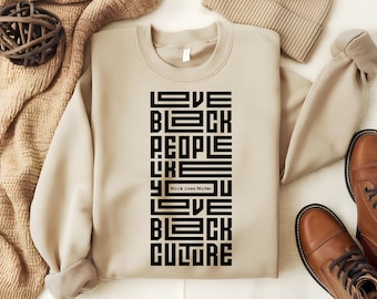 May include: A beige sweatshirt with a black graphic print that reads "Love Black People Like You Love Black Culture" with the text "Black Lives Matter" in a smaller font.