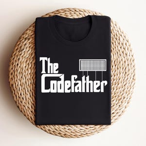 May include: Black t-shirt with white text that reads "The Codefather" and a graphic of a circuit board.