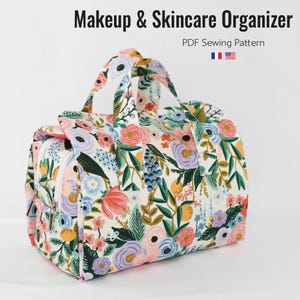 May include: A floral print makeup and skincare organizer with a zipper closure and handles. The bag features a colorful pattern of flowers in pink, purple, blue, and orange on a white background. The text "Makeup & Skincare Organizer" is at the top.
