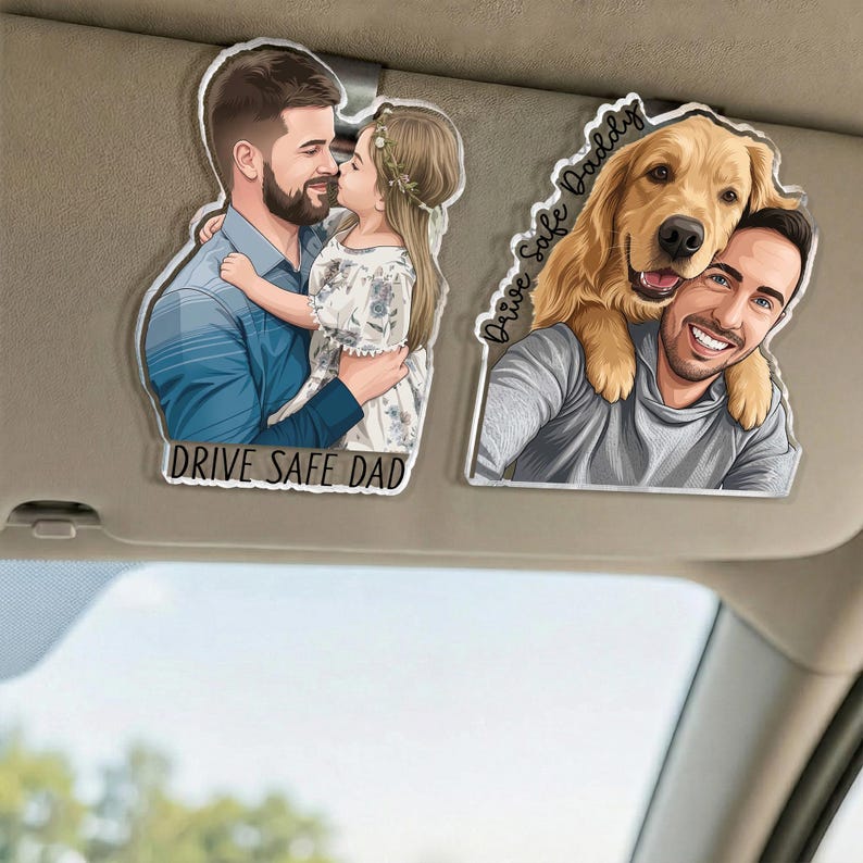May include: Two car visor ornaments. One features a man embracing a girl, with the text "DRIVE SAFE DAD". The other shows a man with a golden retriever, with the text "Drive Safe Daddy". Both are printed on clear acrylic.
