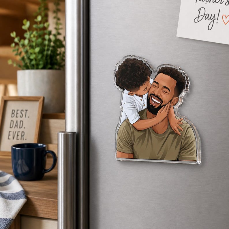 May include: A clear acrylic magnet featuring a cartoon illustration of a father being kissed on the cheek by a child. The father is wearing an olive green shirt and has a dark beard. The child is wearing a white shirt. The words "Best. Dad. Ever." are visible.