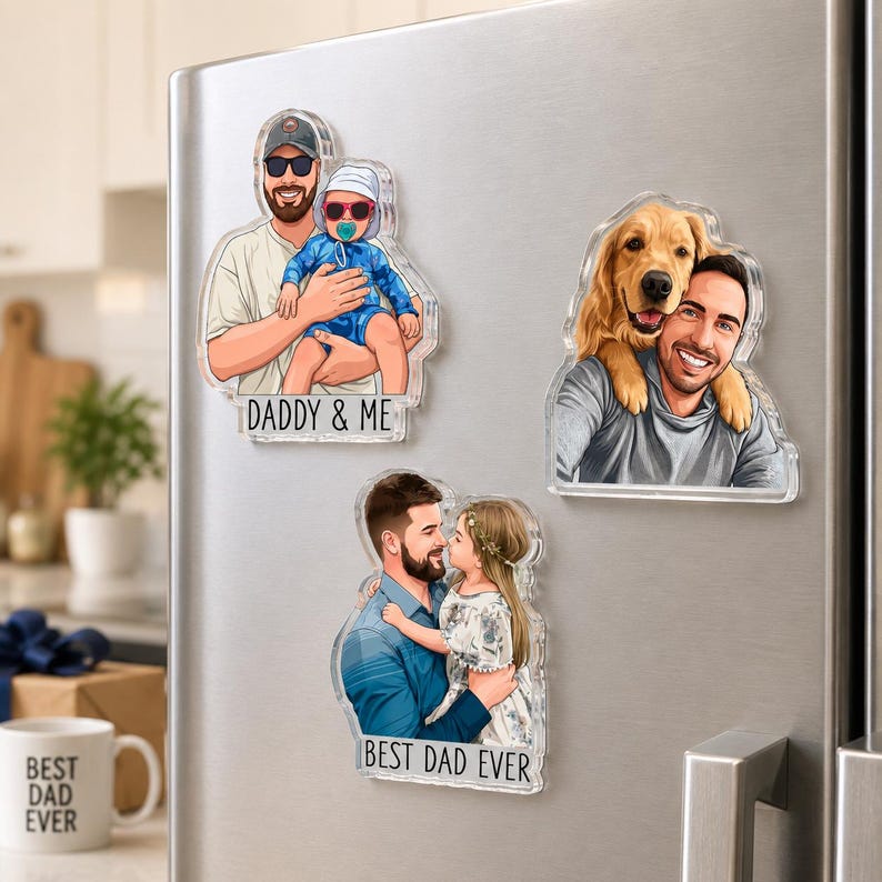 May include: Clear acrylic magnets with cartoon illustrations of a father with a baby, a dog, and a child. The magnets have the phrases "DADDY & ME" and "BEST DAD EVER" printed on them. The magnets are displayed on a silver refrigerator.