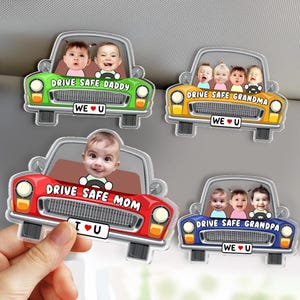 May include: A collection of car-shaped acrylic ornaments with personalized baby photos. Each car has a different color and the text "DRIVE SAFE" followed by "DADDY", "GRANDMA", "MOM", or "GRANDPA". Each has "WE U" or "I U" text.