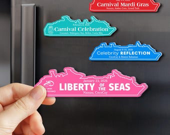 May include: A collection of colorful cruise ship-shaped magnets. The magnets are in red, teal, blue, and pink, each with white text indicating cruise names, dates, and destinations. One pink magnet is held by a hand.