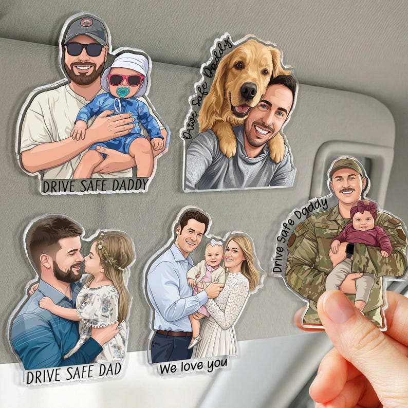 May include: A collection of clear acrylic car charms featuring cartoon illustrations of families and individuals. Each charm has a unique design, including a father holding a baby, a man with a dog, and a family with a baby. Text includes "DRIVE SAFE DADDY" and "We love you."