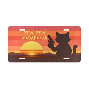 May include: License plate with a sunset design and a black cat silhouette holding a gun. The text "PEW PEW MADAF*KAS" is printed in yellow. The background features horizontal stripes of orange, red, and yellow.