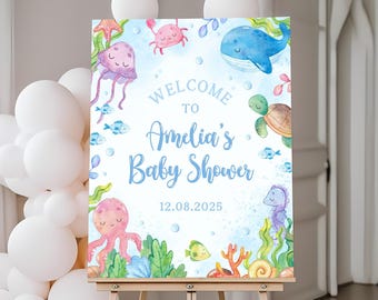 May include: A blue and white welcome sign for a baby shower with a watercolour illustration of sea creatures, including a whale, jellyfish, octopus, crab, turtle, and seahorse. The sign reads "Welcome to Amelia's Baby Shower 12.08.2025".