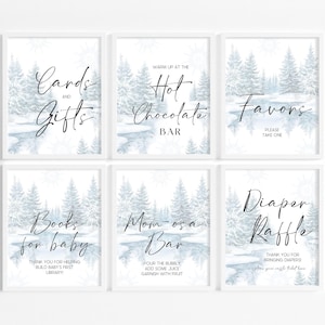 May include: Six framed signs with winter landscape art and calligraphy text. The signs read "Cards and Gifts", "Hot Chocolate Bar", "Favors", "Books for baby", "Mom-osa Bar", and "Diaper Raffle". The signs are white with a winter scene.