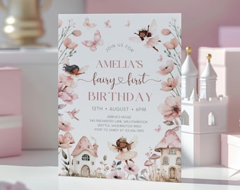 May include: A pink and white birthday invitation with the text "Amelia's fairy first birthday." The invitation features illustrations of fairies, butterflies, flowers, and fairy houses. The date, time, and location are also included.