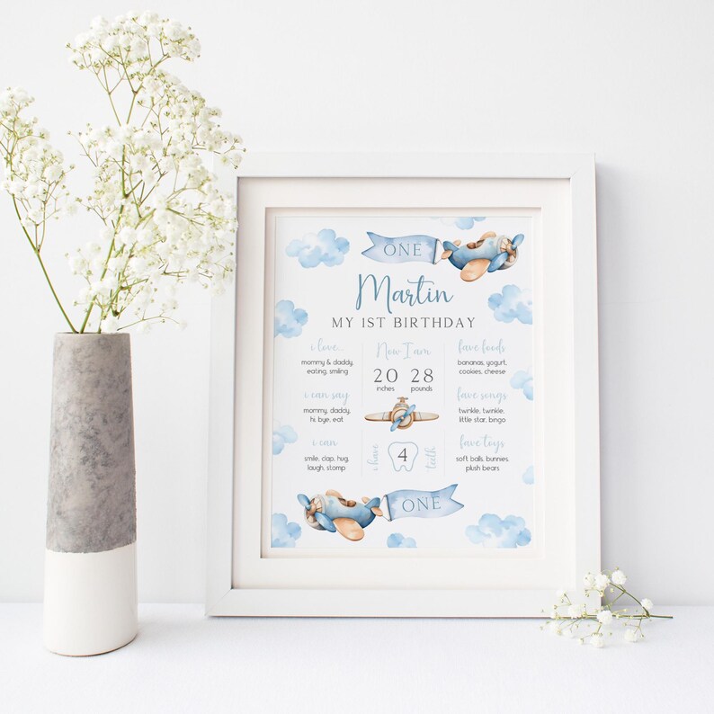 Puede incluir: Un cartel de primer cumplea&ntilde;os imprimible azul y blanco con un dise&ntilde;o de avi&oacute;n de acuarela. El cartel dice "One Martin My 1st Birthday" e incluye detalles sobre el crecimiento del ni&ntilde;o, sus comidas favoritas y las cosas que le encanta hacer.
