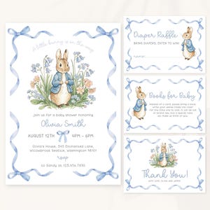 May include: Baby shower invitation set featuring a watercolor illustration of a bunny in a blue jacket surrounded by flowers. The invitation includes details for Olivia Smith's baby shower, with RSVP information and additional cards.