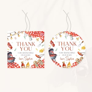 Puede incluir: Dos etiquetas de agradecimiento para baby shower. Una es cuadrada, la otra redonda. Ambas presentan un tema de barbacoa en acuarela con el texto "Thank You For Showering Our Baby, love, Sophia". Las etiquetas tienen un patrón de cuadros rojos y blancos.