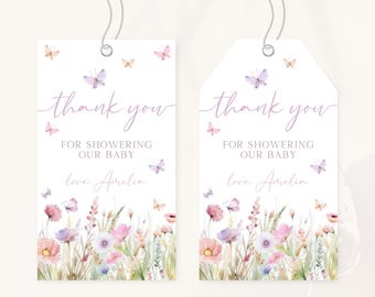 May include: Two white gift tags with a floral and butterfly design. The tags have the words "thank you" in cursive, along with the text "For showering our baby" and "love, Amelia". The bottom of the tags feature watercolor flowers.