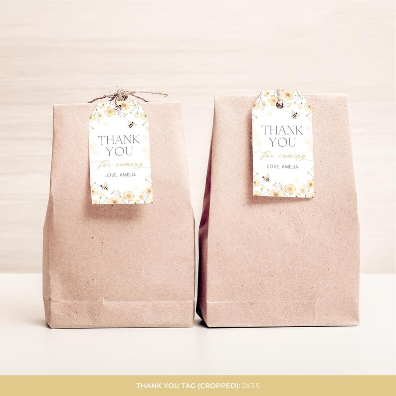 May include: Two brown paper gift bags with tags. The tags feature a floral design with bees and the text "THANK YOU for coming LOVE AMELIA". The tags are attached with twine.