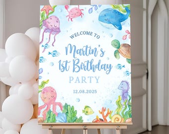 May include: A blue and white welcome sign with a watercolour illustration of sea creatures. The sign says "Welcome to Martin's 1st Birthday Party 12.08.2025".